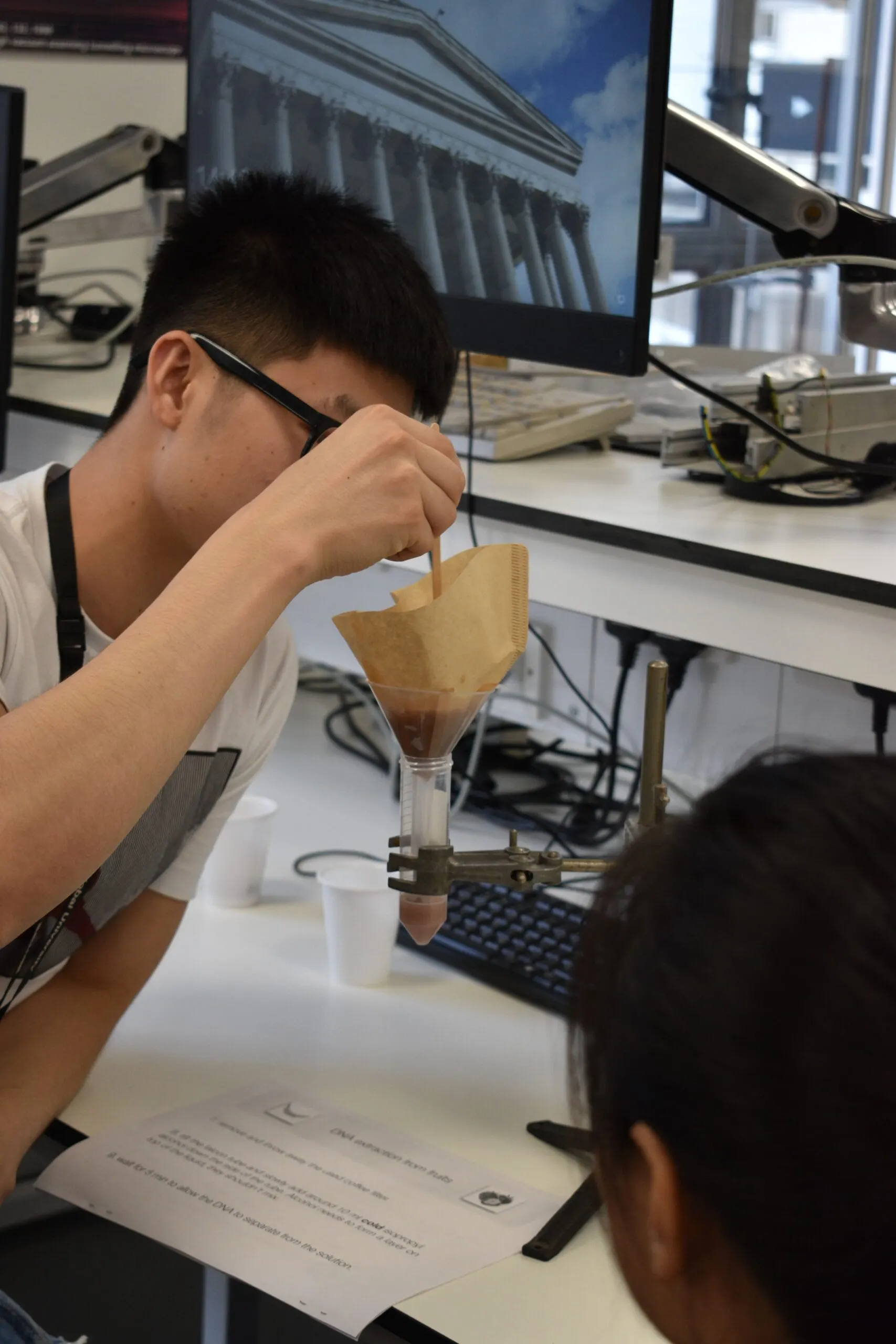A summer school student running a practical experiment at a laboratory workstation